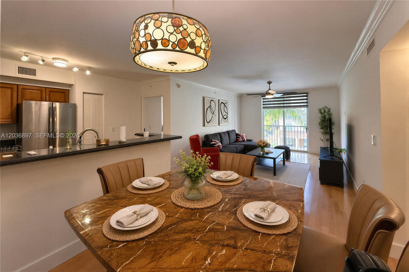 A dining area with a marble table overlooks a living room and a balcony — 1900 Van Buren St # 317B, Hollywood FL 33020, HOLLYWOOD, FL
