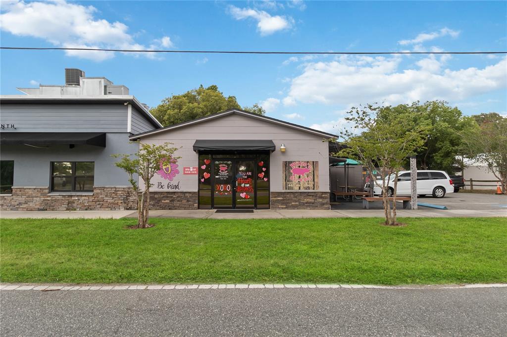A single-story commercial building with a gray facade, stone base, and a glass storefront — 17436 7TH STREET, MONTVERDE, FL