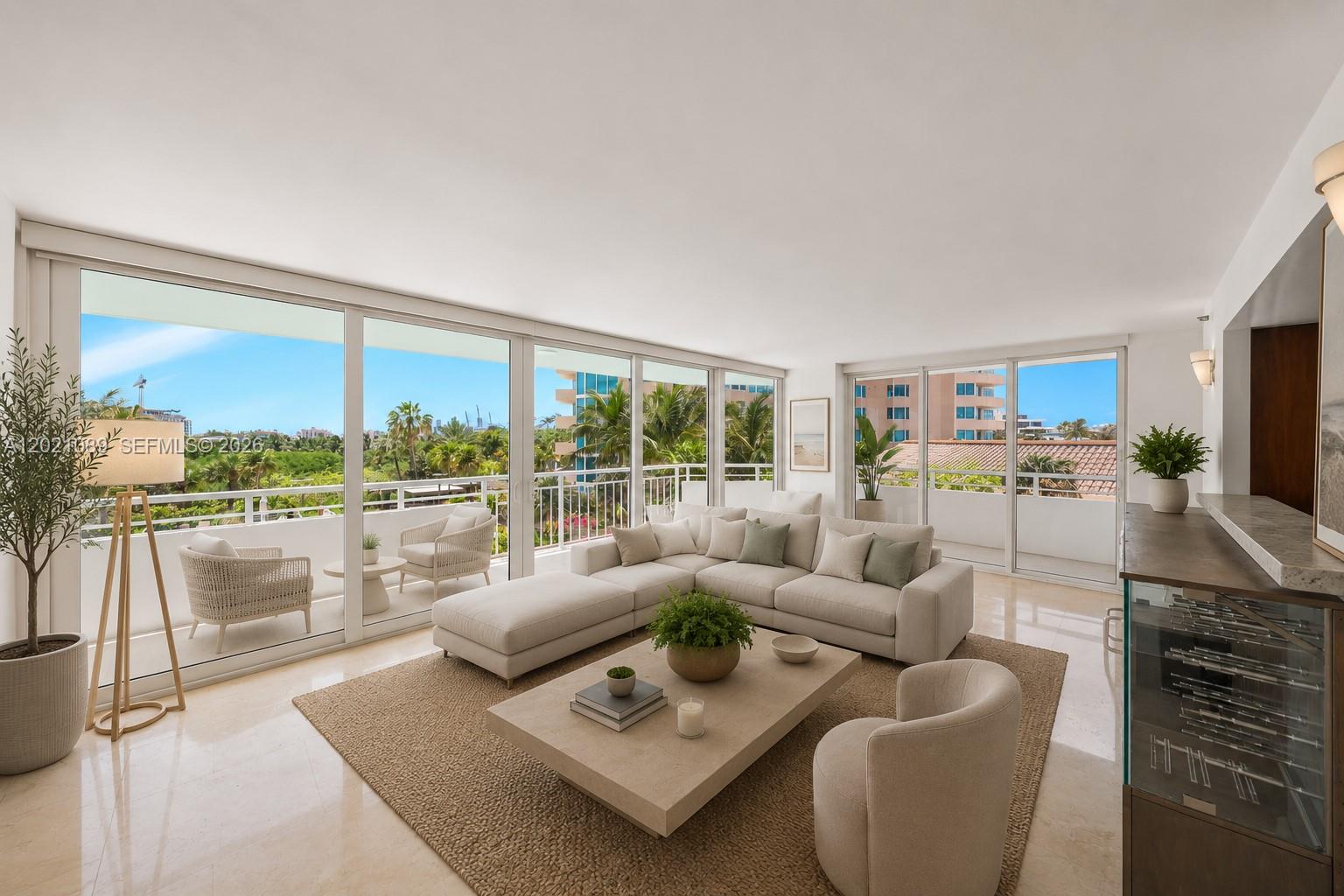 A bright living room features a large sectional sofa, a coffee table, and floor-to-ceiling windows — 400 S Pointe Dr # 409, Miami Beach FL 33139, MIAMI BEACH, FL