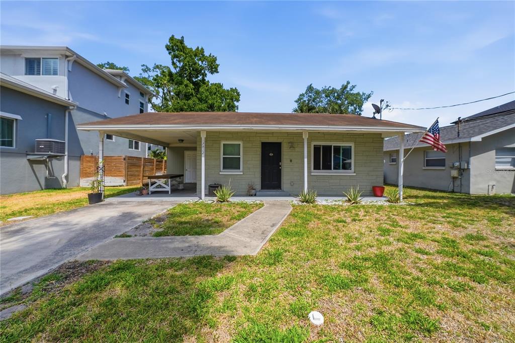 A single-story house with a stone facade, a front carport, and a concrete walkway — 7412 S SHERRILL STREET, TAMPA, FL
