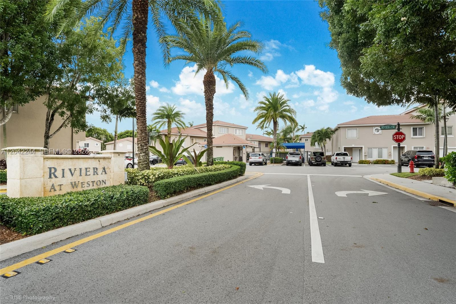 The entrance to the Riviera at Weston community features a stone sign and palm trees — 221 Riviera Cir, Weston FL 33326, WESTON, FL