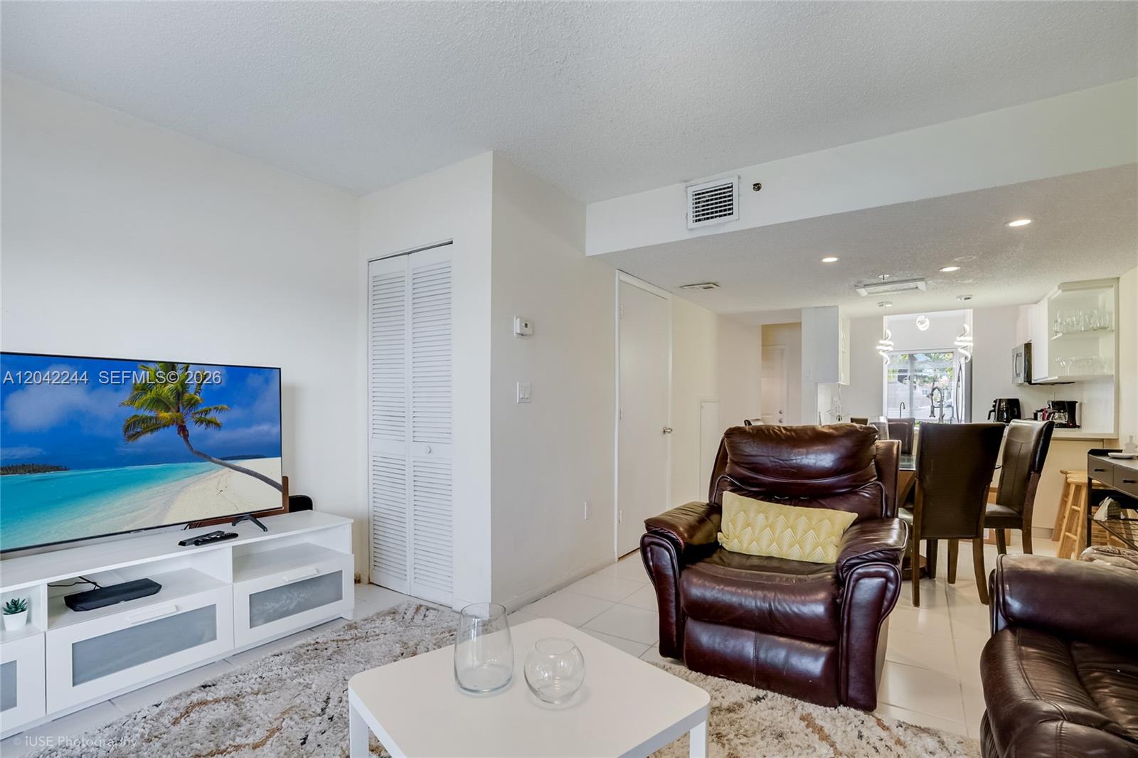 A living room features white tile floors, a brown leather recliner, and a white media console — 221 Riviera Cir, Weston FL 33326, WESTON, FL