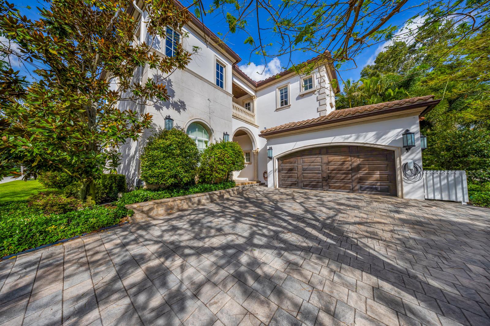 A two-story stucco house with a wooden garage door and a paved driveway — 629 Boca Marina Court, Boca Raton FL 33487, BOCA RATON, FL