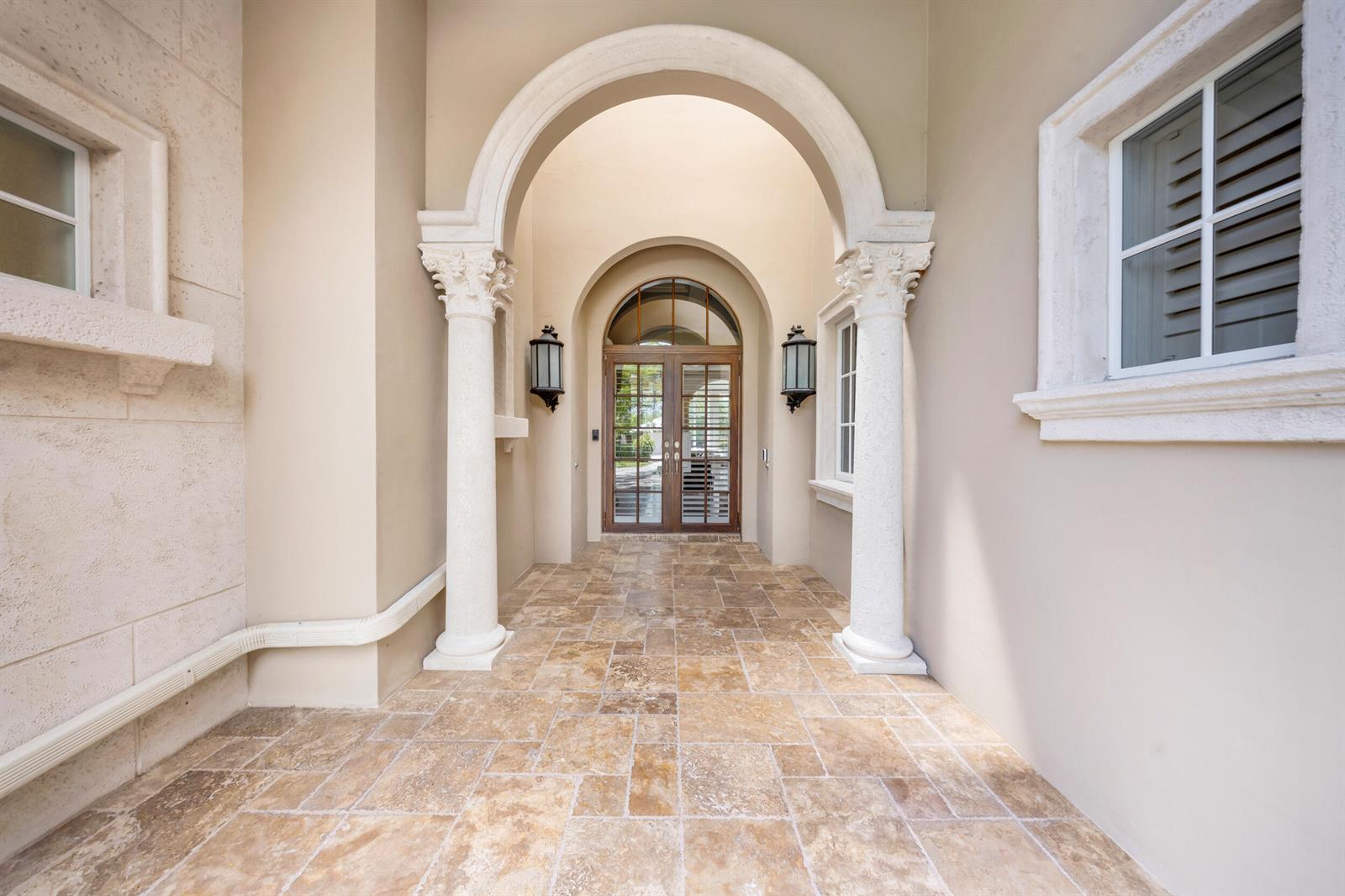 A covered entryway features stone tile flooring, two white columns, and a double glass door — 629 Boca Marina Court, Boca Raton FL 33487, BOCA RATON, FL