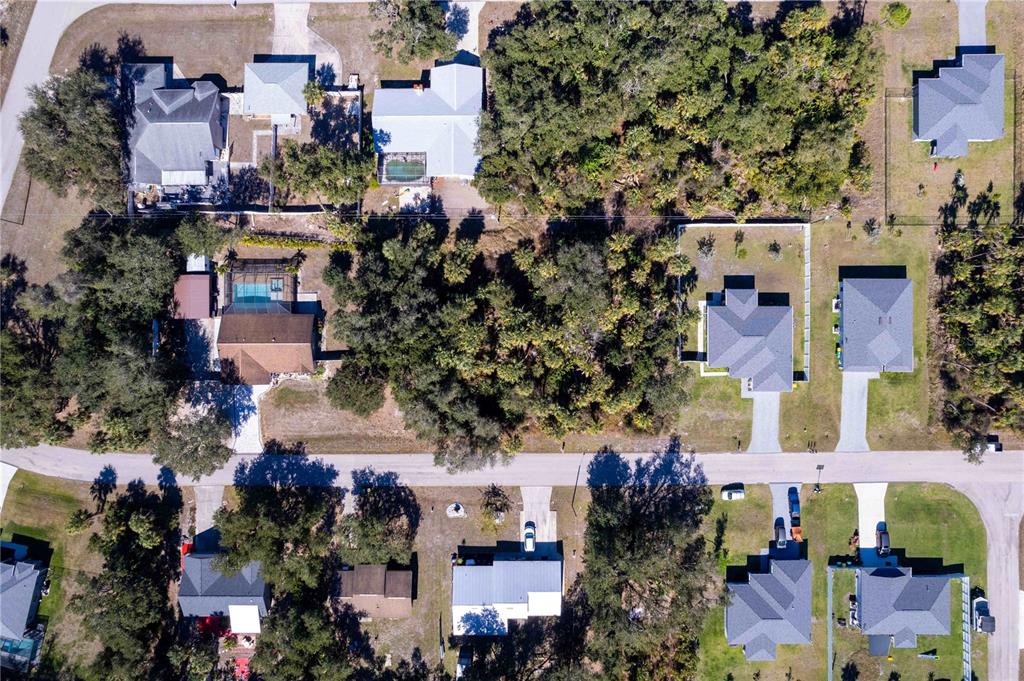 Aerial view of a residential neighborhood with several houses, swimming pools, and wooded lots — 16250 BANYAN AVENUE, PORT CHARLOTTE, FL
