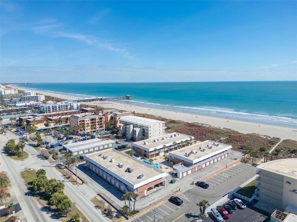 An aerial view of beachfront hotel buildings and a parking lot near the ocean — 5000 OCEAN BEACH BOULEVARD UNIT B11, COCOA BEACH, FL