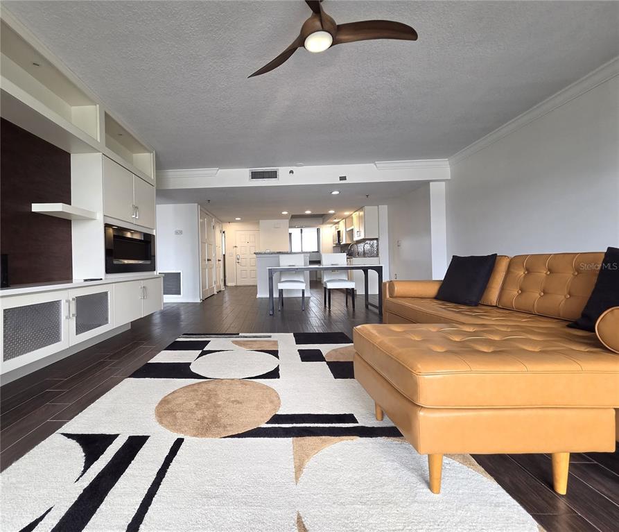 A living room features a tan leather sectional, a geometric rug, and a built-in media unit — 530 E CENTRAL BOULEVARD UNIT 604, ORLANDO, FL