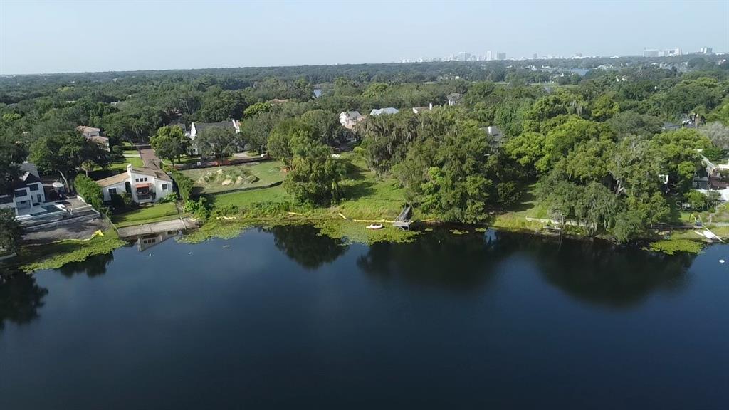 An aerial view shows a lakefront property with a house, a dock, and surrounding trees — 1415 GROVE TERRACE, WINTER PARK, FL