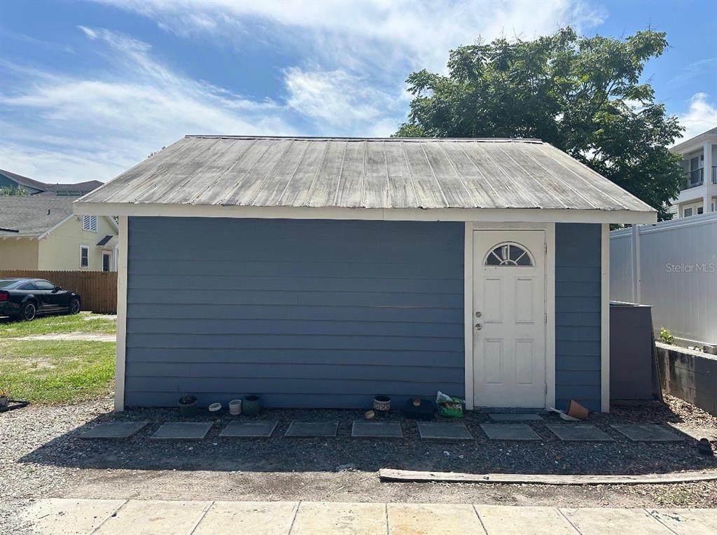 A blue detached garage with a metal roof and a white door — 129 E CONCORD STREET UNIT 5, ORLANDO, FL