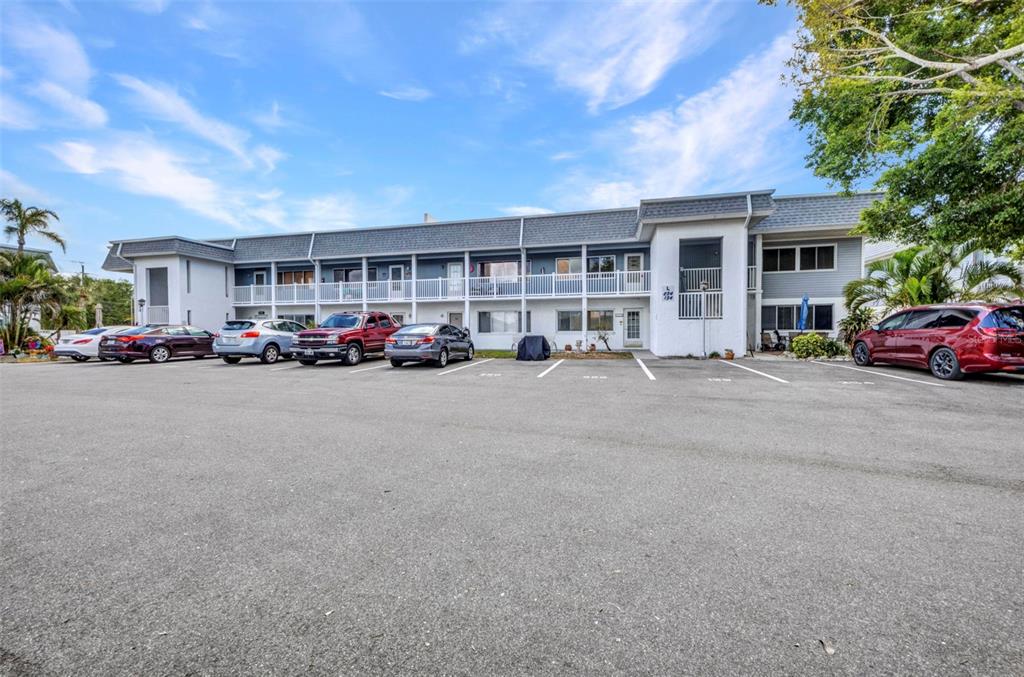 A two-story apartment building with a parking lot in front under a blue sky — 22375 EDGEWATER DRIVE UNIT 255, PUNTA GORDA, FL