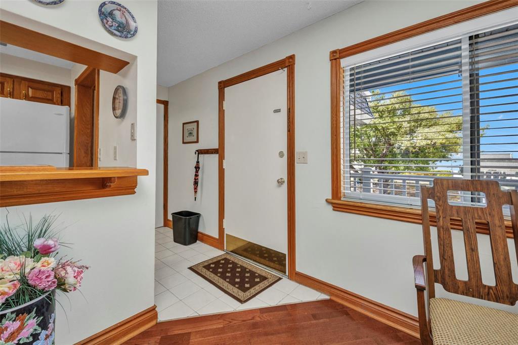 An entryway features a white door, tile flooring, wood trim, and a window with blinds — 22375 EDGEWATER DRIVE UNIT 255, PUNTA GORDA, FL