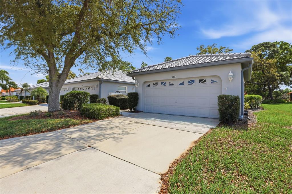 A single-story house with a light-colored exterior, a two-car garage, and a concrete driveway — 5721 CASA DEL SOL BOULEVARD UNIT 3223, SARASOTA, FL