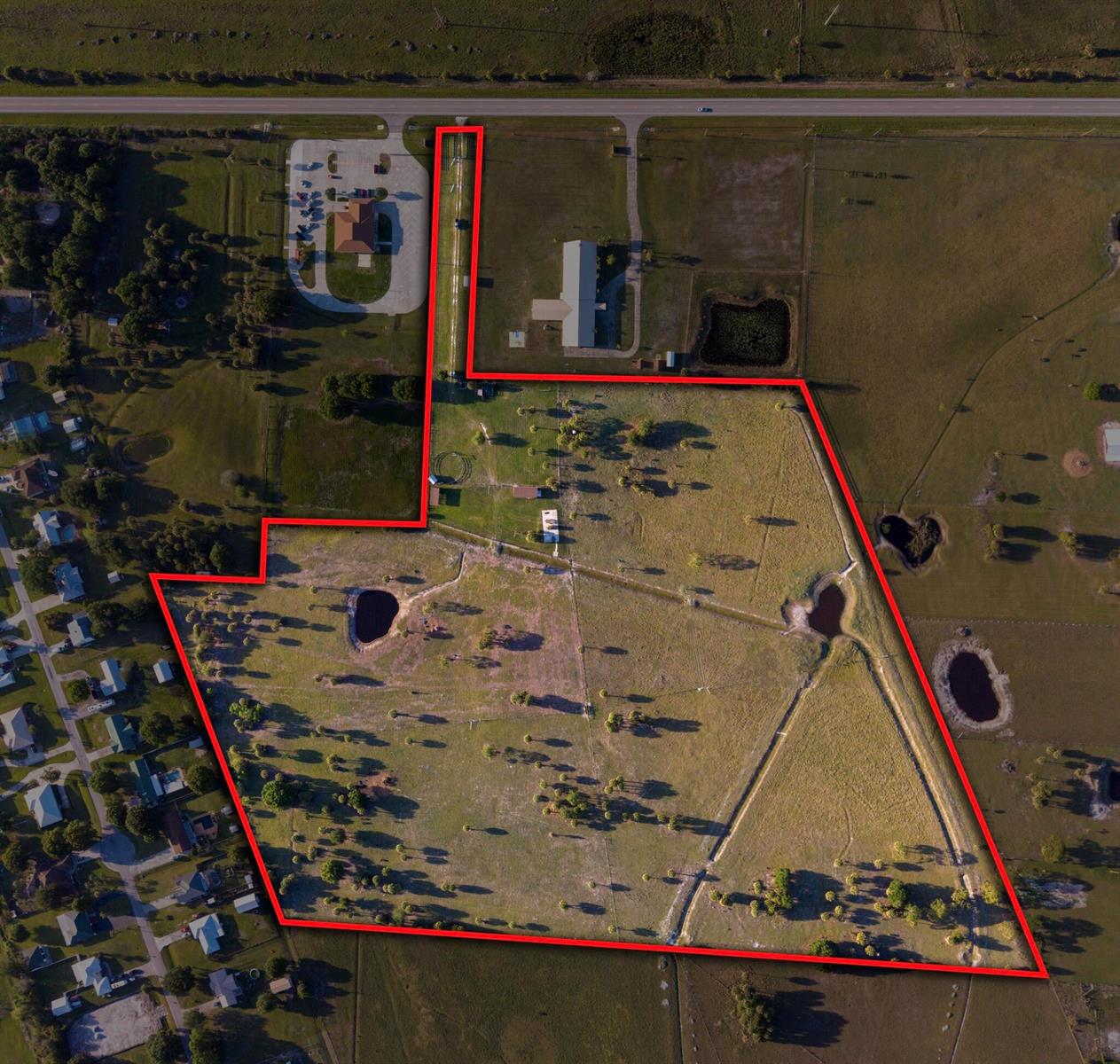 An aerial view shows a large, irregularly shaped parcel of land outlined in red — 8164 Highway 70 W, Okeechobee FL 34972, OKEECHOBEE, FL
