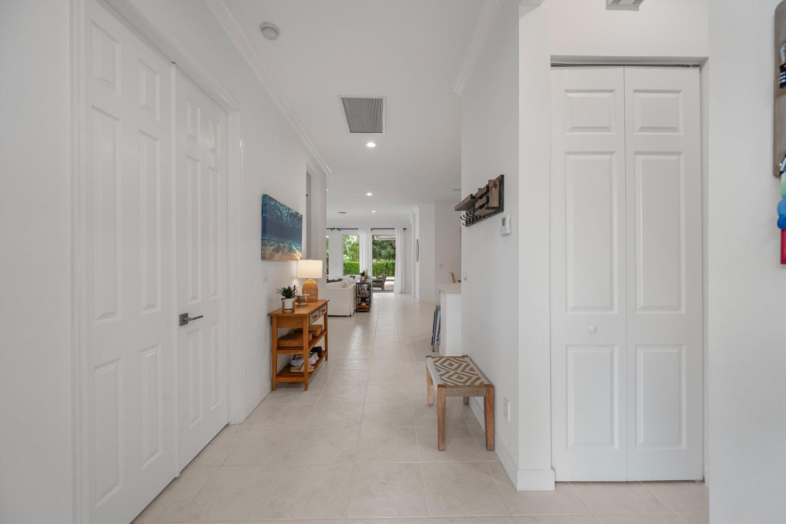A bright hallway features white walls, tile flooring, a wooden console table, and a bench — 2920 Twin Oaks Way, Wellington FL 33414, WELLINGTON, FL