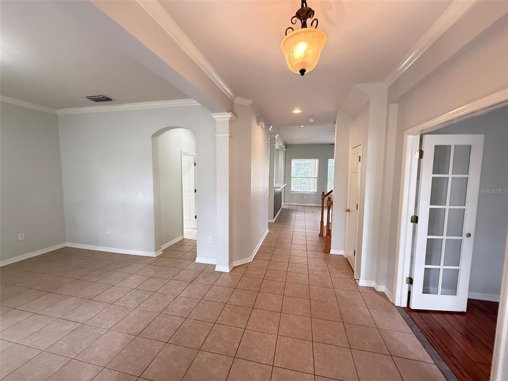 A tiled hallway leads past an arched entryway toward a room with a staircase — 8523 NORTHTON GROVES BOULEVARD, ODESSA, FL
