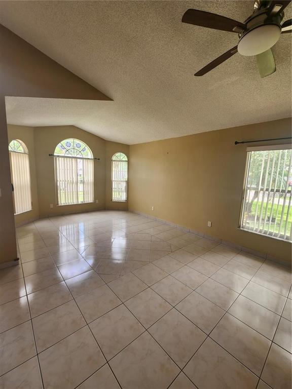 A single-story house with an orange stucco exterior, a two-car garage, and a palm tree — 2483 SHELBY CIRCLE, KISSIMMEE, FL