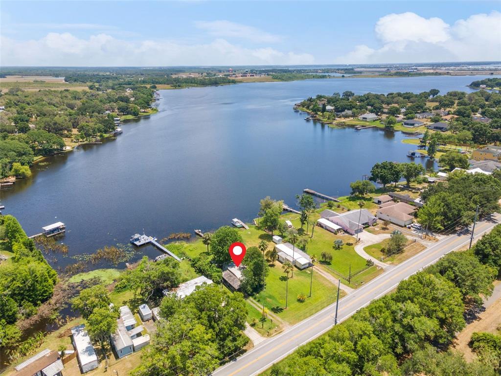 An aerial view shows a house with a red location pin beside a large lake — 7570 BERKLEY ROAD, POLK CITY, FL