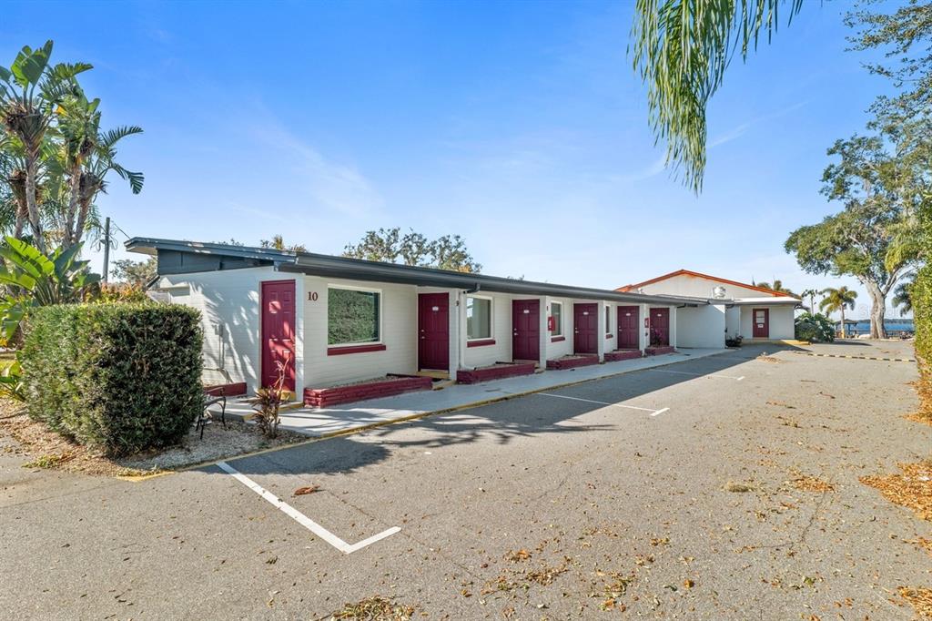 A single-story motel building with maroon doors and parking spaces in front — 6264 ALLIGATOR LAKE SHORE E, ST CLOUD, FL