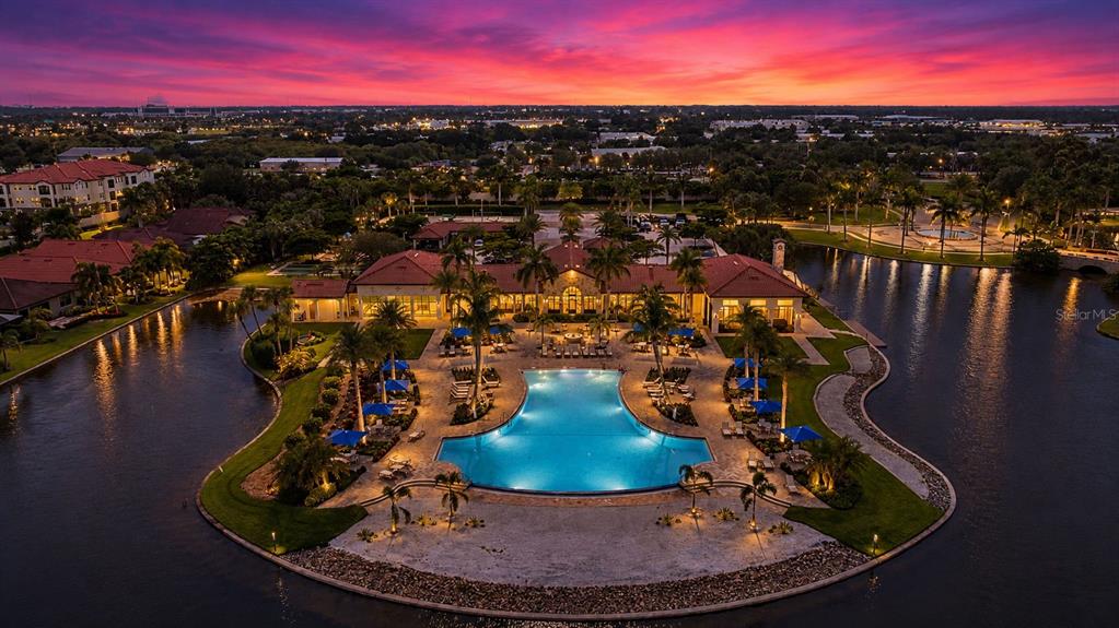 An aerial view of a resort-style swimming pool surrounded by palm trees and a clubhouse — 145 SOLIERA STREET, NORTH VENICE, FL