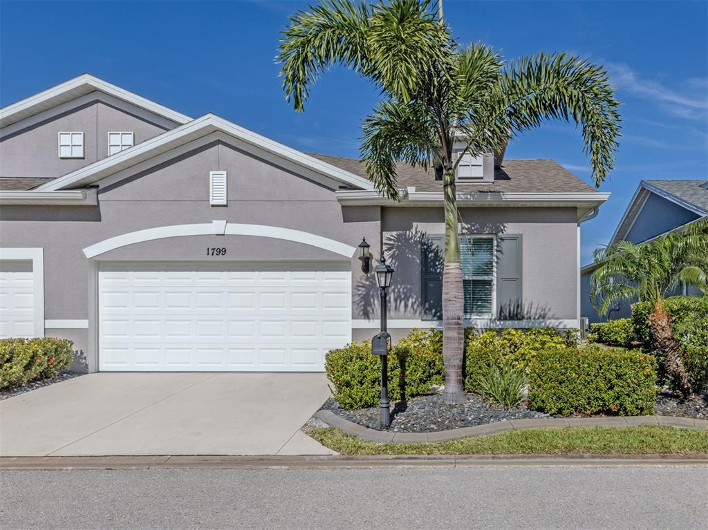 A gray house with a white garage door and a palm tree in the front yard — 1799 NOTTINGHAM TRAIL, PUNTA GORDA, FL