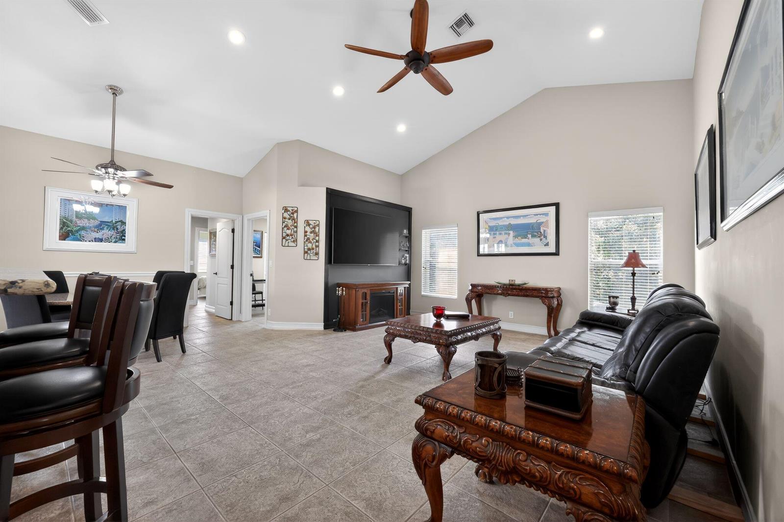 A living room with tile floors, a vaulted ceiling, a ceiling fan, and black furniture — 12301 Cabot Court, Boca Raton FL 33428, BOCA RATON, FL