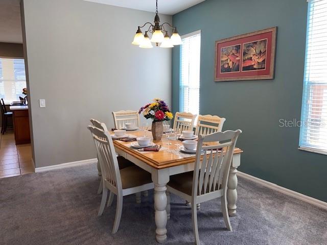 A dining room features a wooden table with six chairs under a chandelier — 842 SUSSEX DRIVE, DAVENPORT, FL