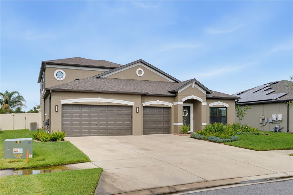 A two-story suburban house with a three-car garage and a concrete driveway — 7903 LAGO MIST WAY, WESLEY CHAPEL, FL