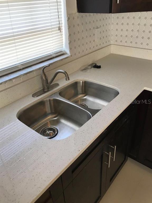 A kitchen sink with a stainless steel faucet is set into a white speckled countertop — 2400 NW 21ST STREET UNIT 3, FORT LAUDERDALE, FL