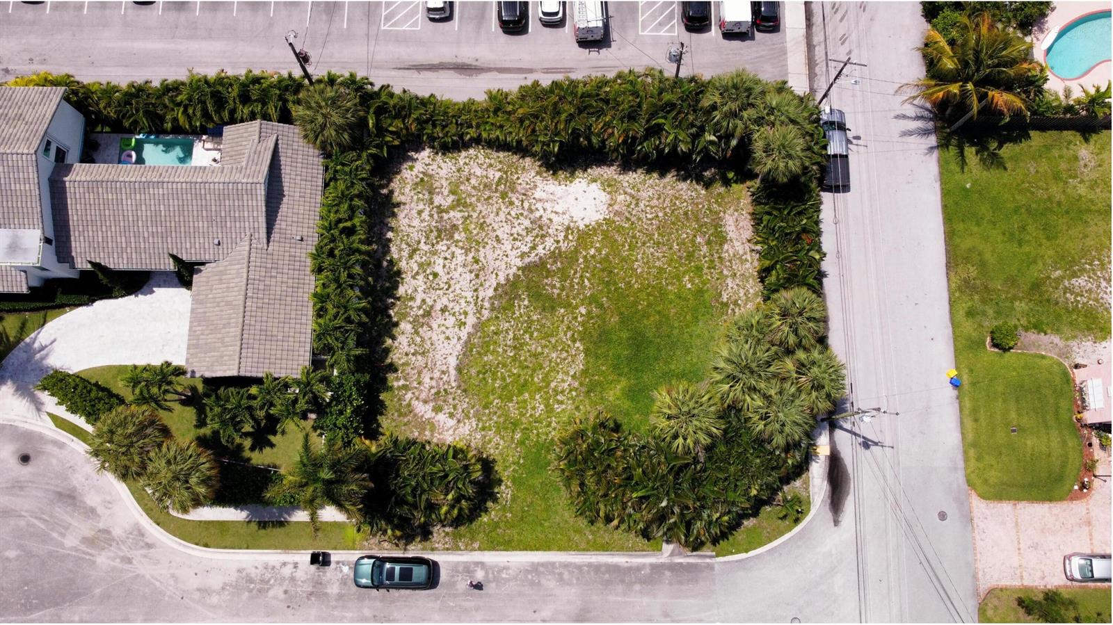An aerial view shows a vacant, rectangular residential lot surrounded by palm trees and landscaping — 7 Lakeside Palms Court, FL 33460, FL