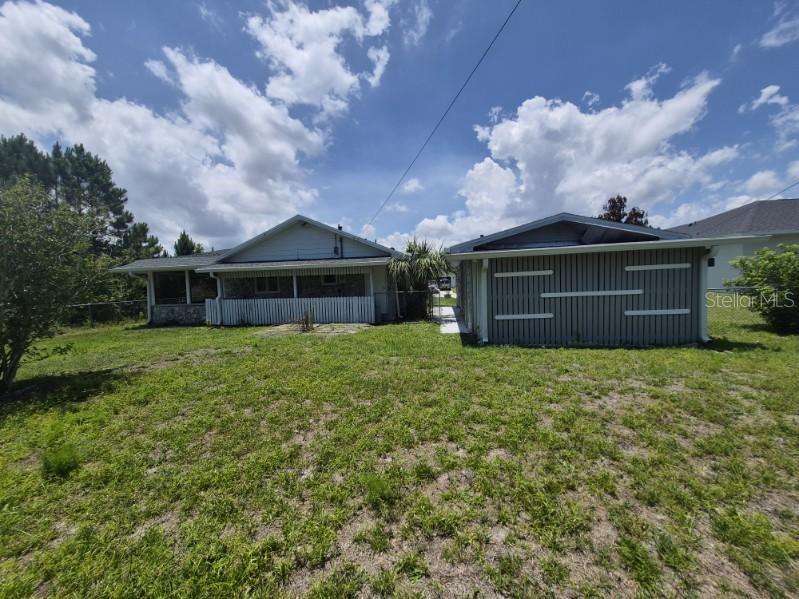 The exterior view shows a house with a covered porch and an adjacent detached garage — 757 TALMADGE AVENUE SE, PALM BAY, FL