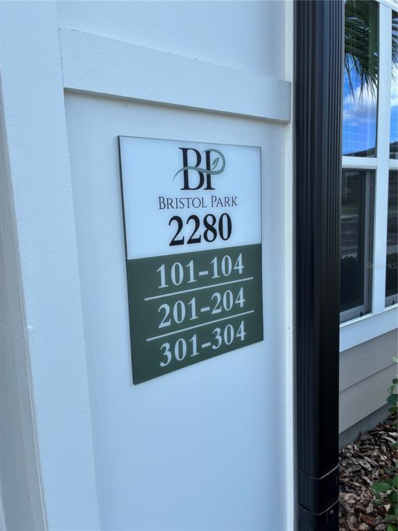 A sign on a white wall displays the building number 2280 and unit ranges — 2280 WATERFALL COURT UNIT 4-302, MOUNT DORA, FL
