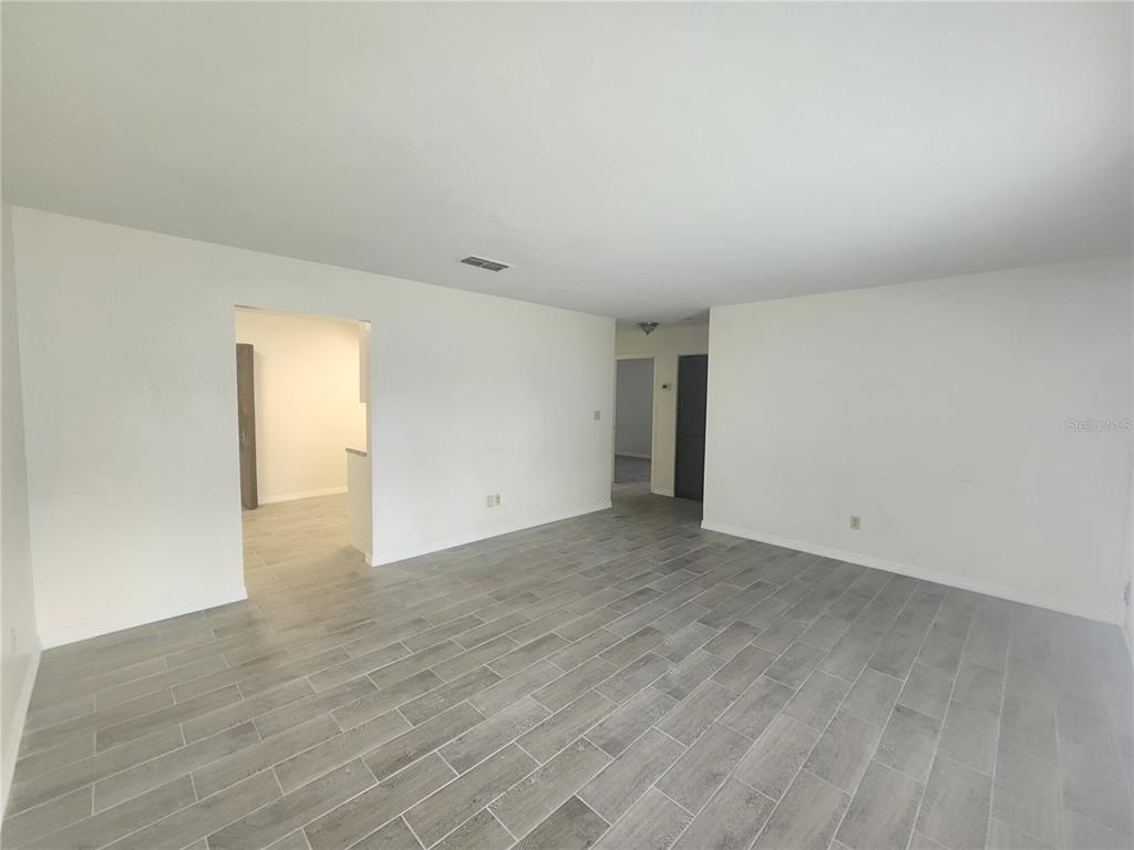 An empty room with white walls and gray wood-look tile flooring — 5817 NW 23 TERRACE UNIT 2, GAINESVILLE, FL
