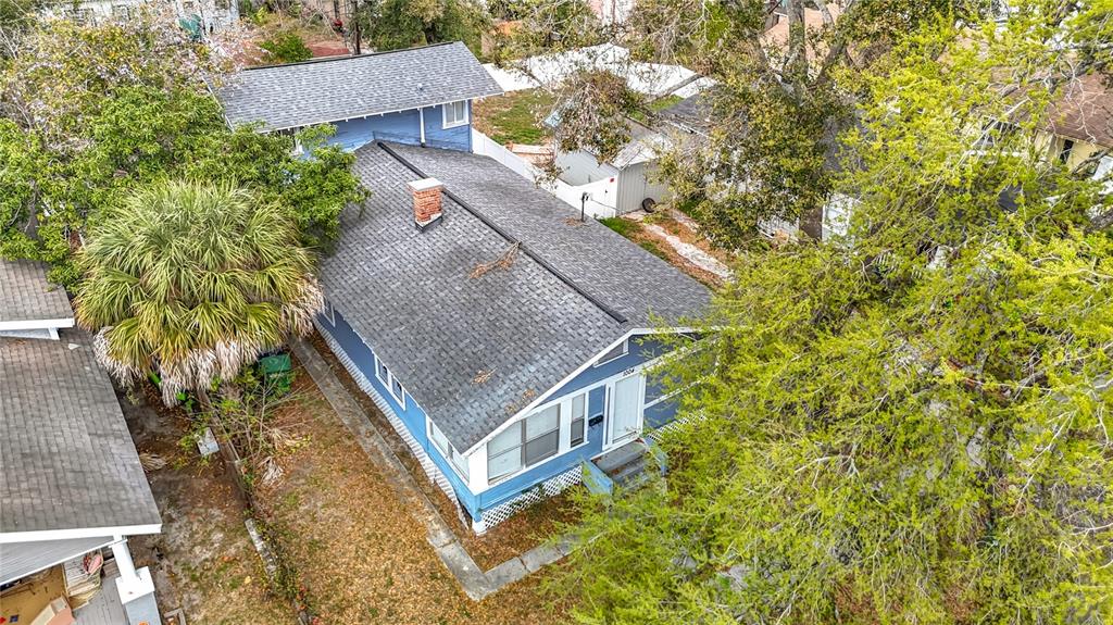 An aerial view shows a blue house with a gray shingled roof and a chimney — 1004 E 22ND AVENUE, TAMPA, FL