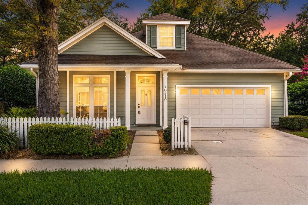 A single-story house with sage green siding, a white front door, and a two-car garage — 10310 SW 51ST LANE, GAINESVILLE, FL