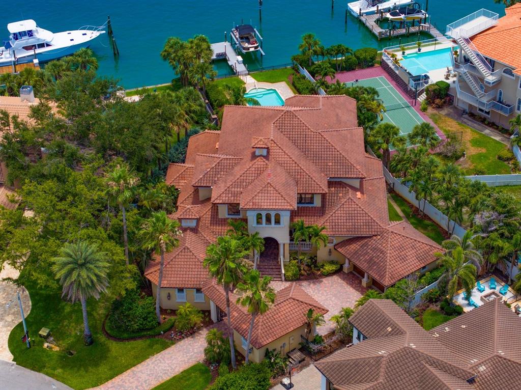 An aerial view of a large waterfront home with a tile roof, pool, and tennis court — 841 PONCE DE LEON DRIVE, ST PETERSBURG, FL