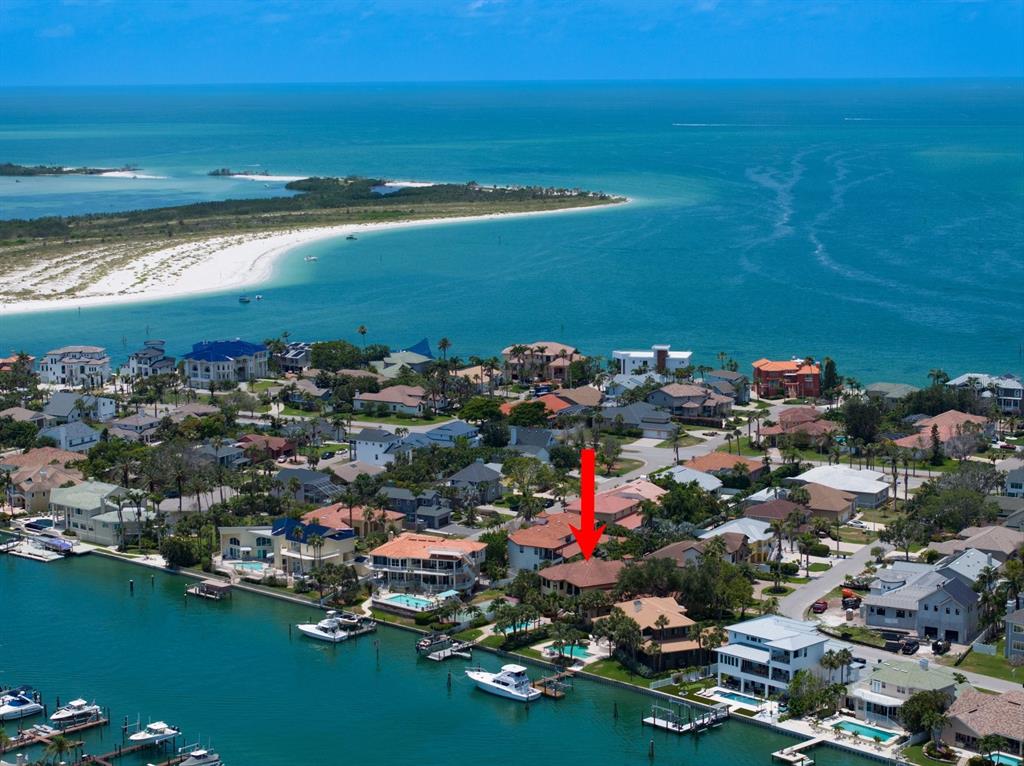An aerial view shows a waterfront residential neighborhood with a red arrow pointing to a house — 841 PONCE DE LEON DRIVE, ST PETERSBURG, FL