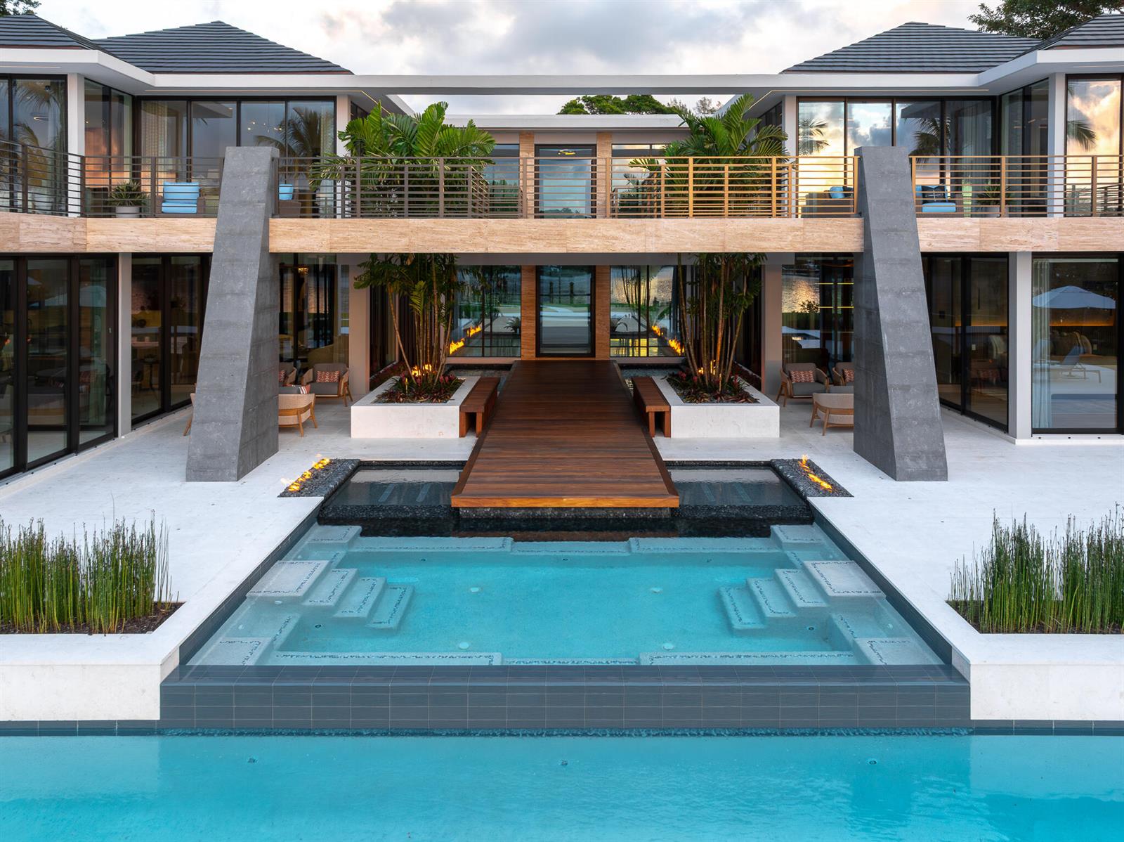 A modern two-story house features a wooden walkway over a pool leading to a central entrance — 488 S Beach Road, Jupiter Island FL 33455, JUPITER ISLAND, FL