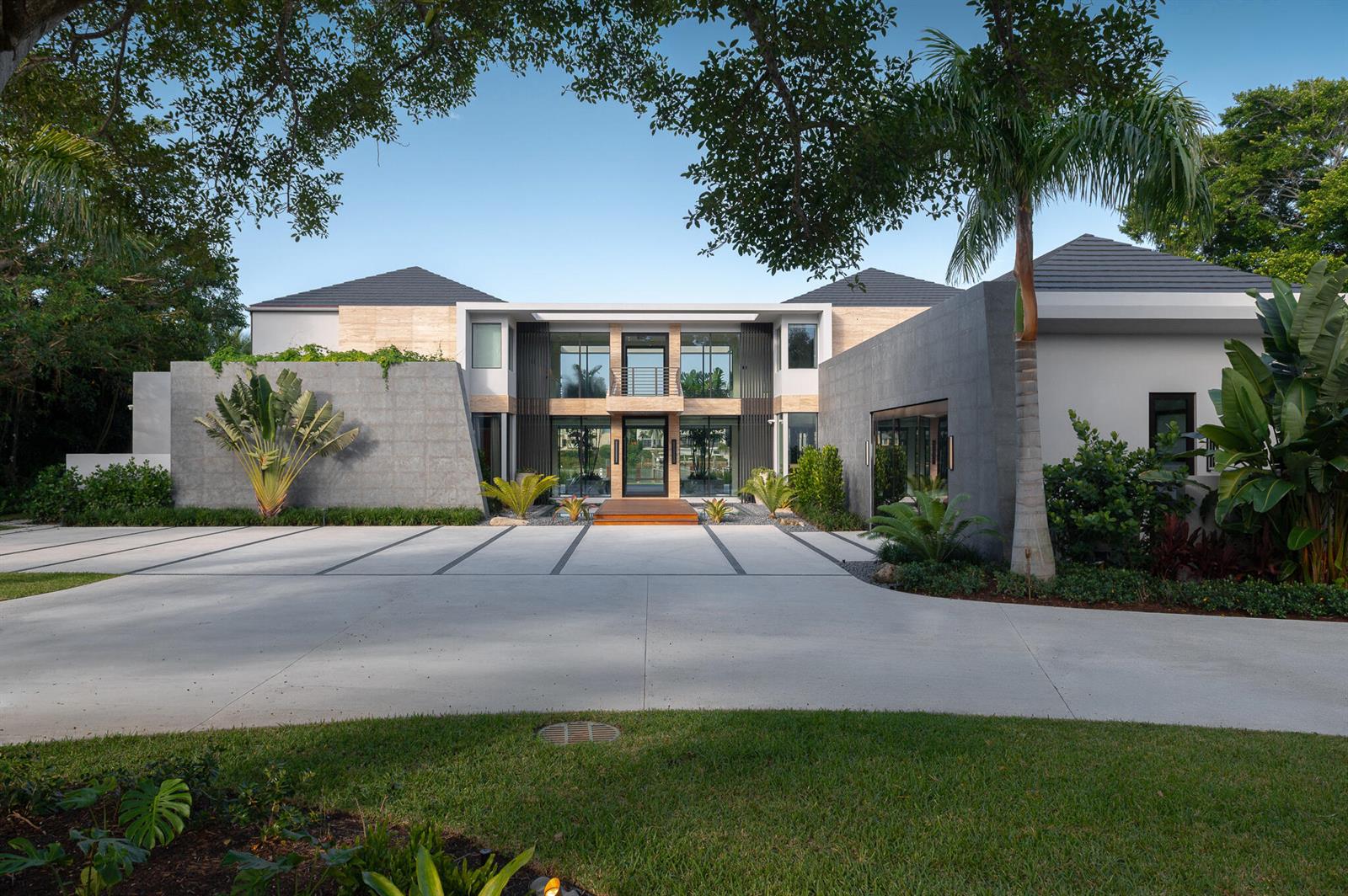 A modern two-story house with a concrete driveway, stone facade, and large glass entryway — 488 S Beach Road, Jupiter Island FL 33455, JUPITER ISLAND, FL