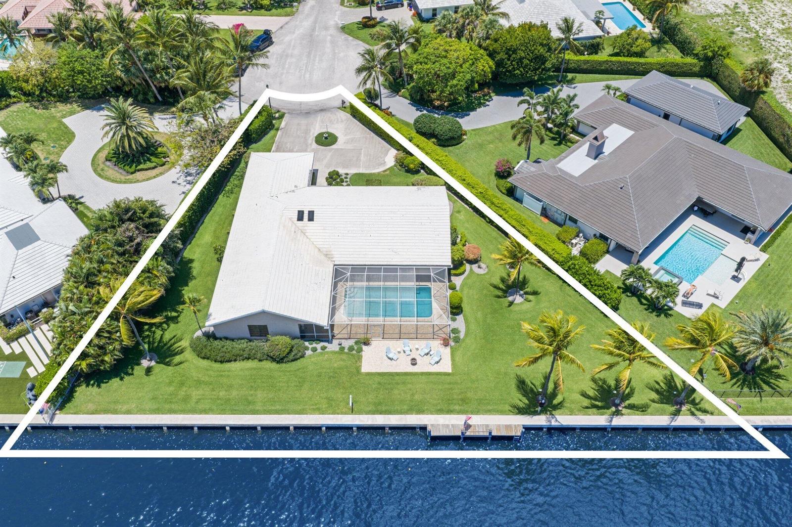 An aerial view shows a house with a pool and dock on a waterfront lot — 970 Orchid Lane, Gulf Stream FL 33483, GULF STREAM, FL
