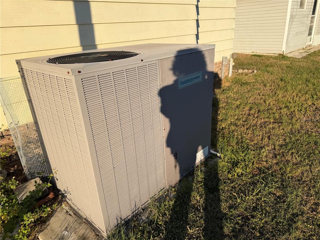 A beige Comfortmaker HVAC unit sits on the grass next to a house exterior — 4165 ROLLING OAKS DRIVE, WINTER HAVEN, FL
