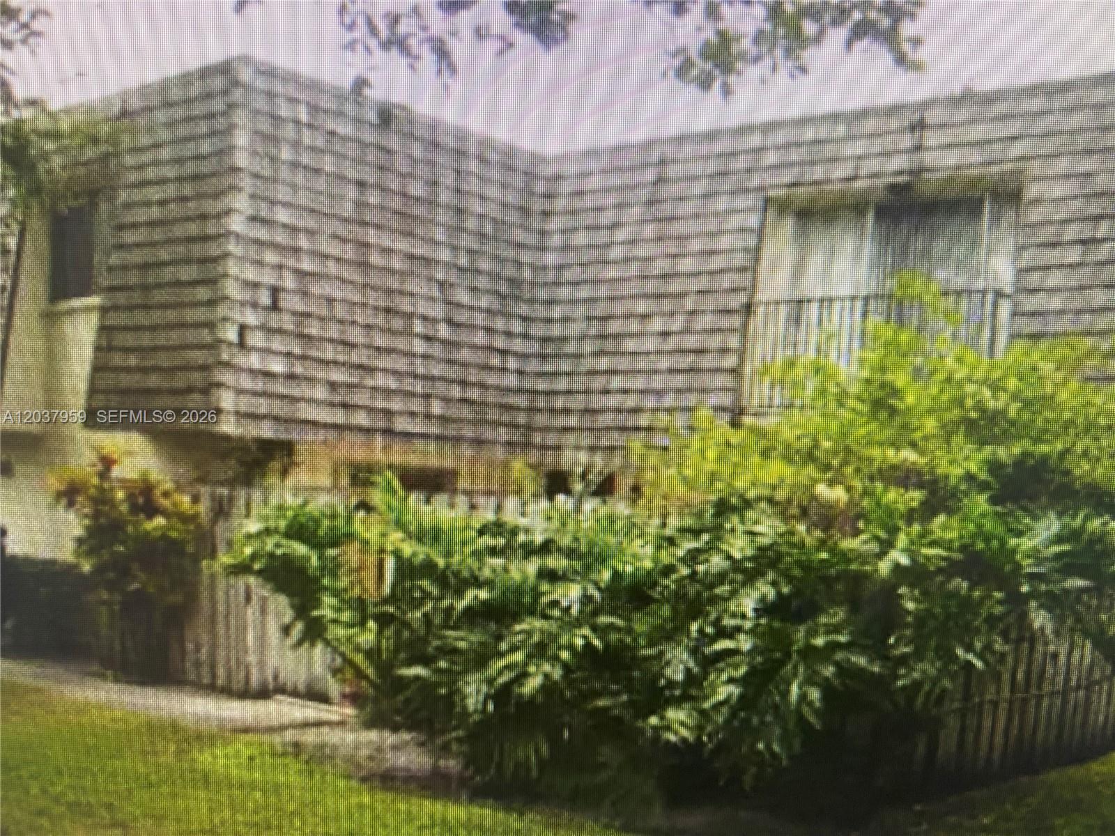 A two-story building with a shingled exterior and a balcony surrounded by lush landscaping — 2060 SW 90th Ave # 18, Davie FL 33324, DAVIE, FL