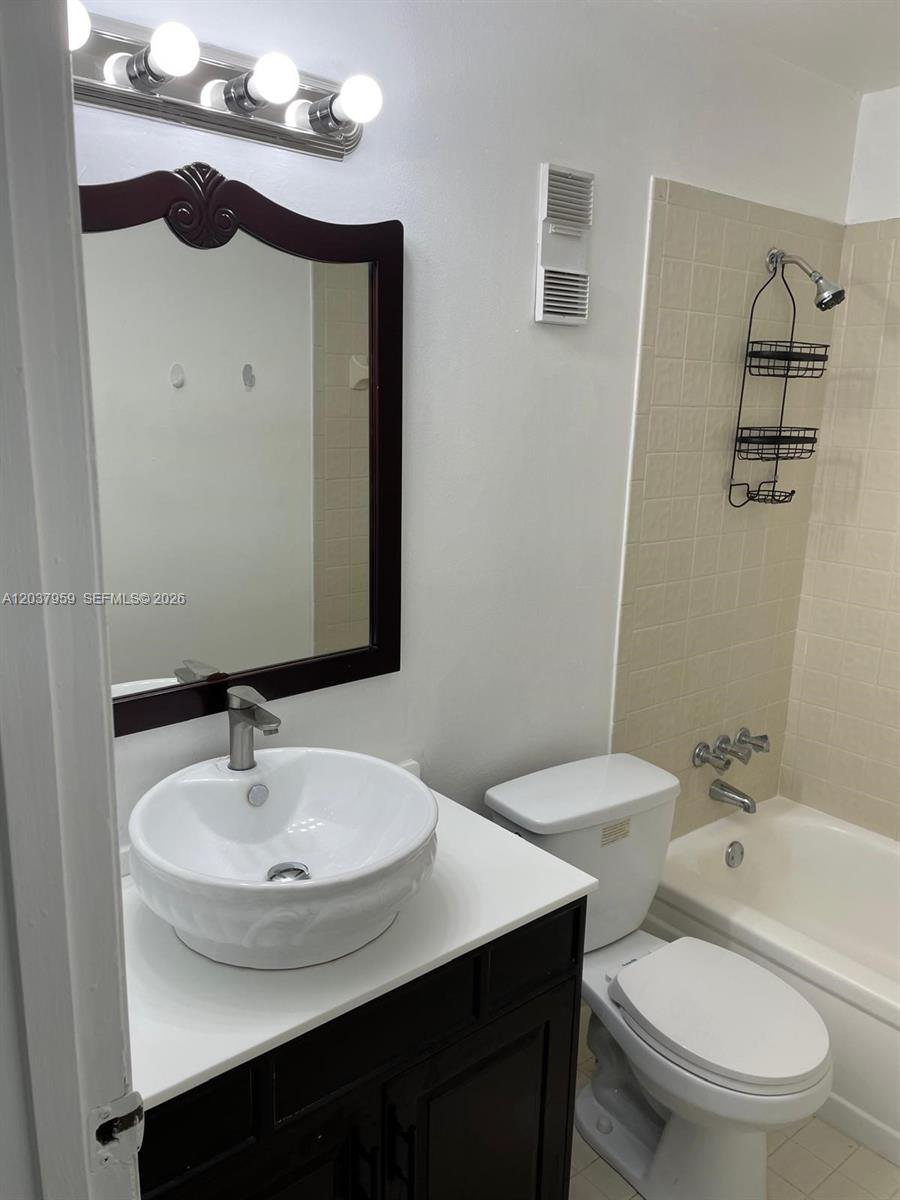 A bathroom features a vessel sink vanity, a dark wood-framed mirror, and a tiled tub — 2060 SW 90th Ave # 18, Davie FL 33324, DAVIE, FL