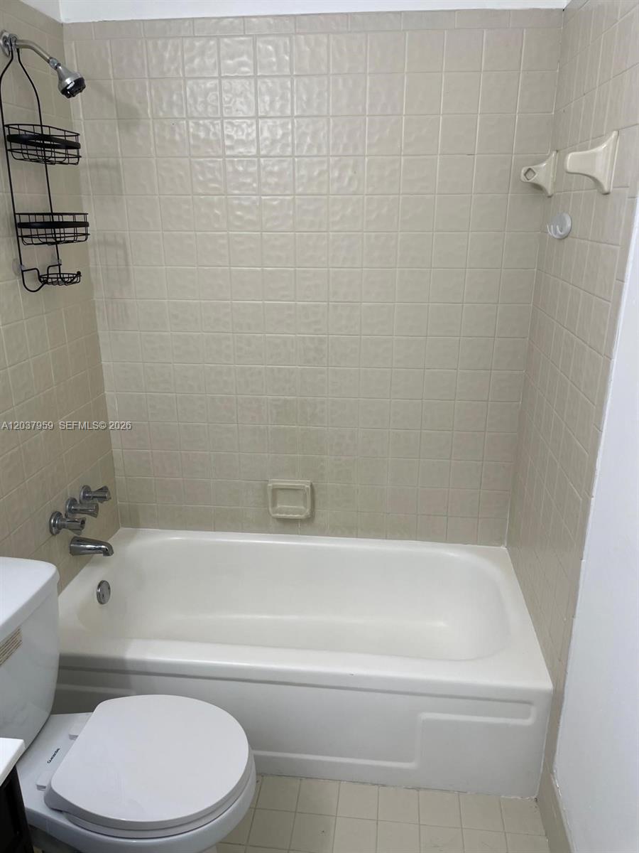A bathroom features a white bathtub with a beige tiled surround and a shower head — 2060 SW 90th Ave # 18, Davie FL 33324, DAVIE, FL