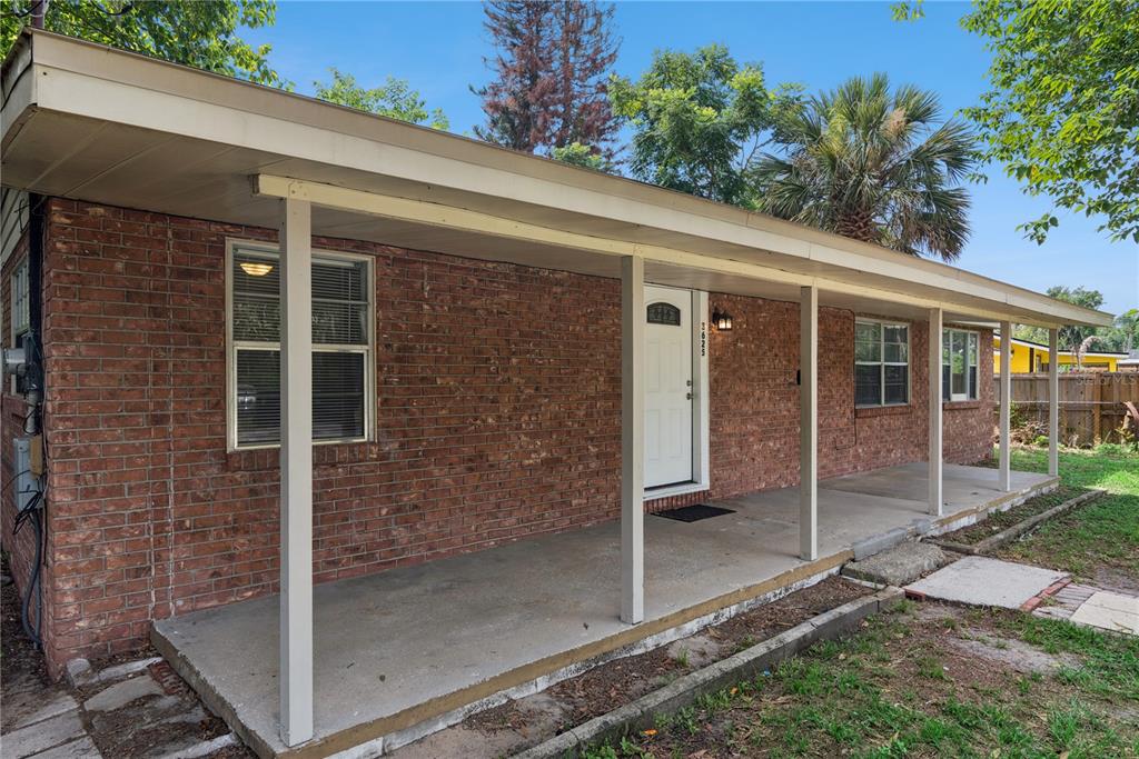 A single-story brick house features a long covered front porch with white support columns — 3625 COCHRAN STREET, APOPKA, FL
