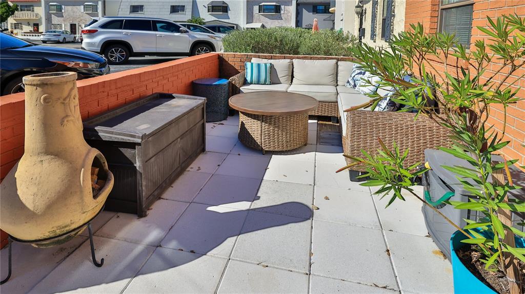 A patio features a wicker sectional, a round coffee table, a chiminea, and storage bins — 625 N HALIFAX AVENUE UNIT 28, DAYTONA BEACH, FL