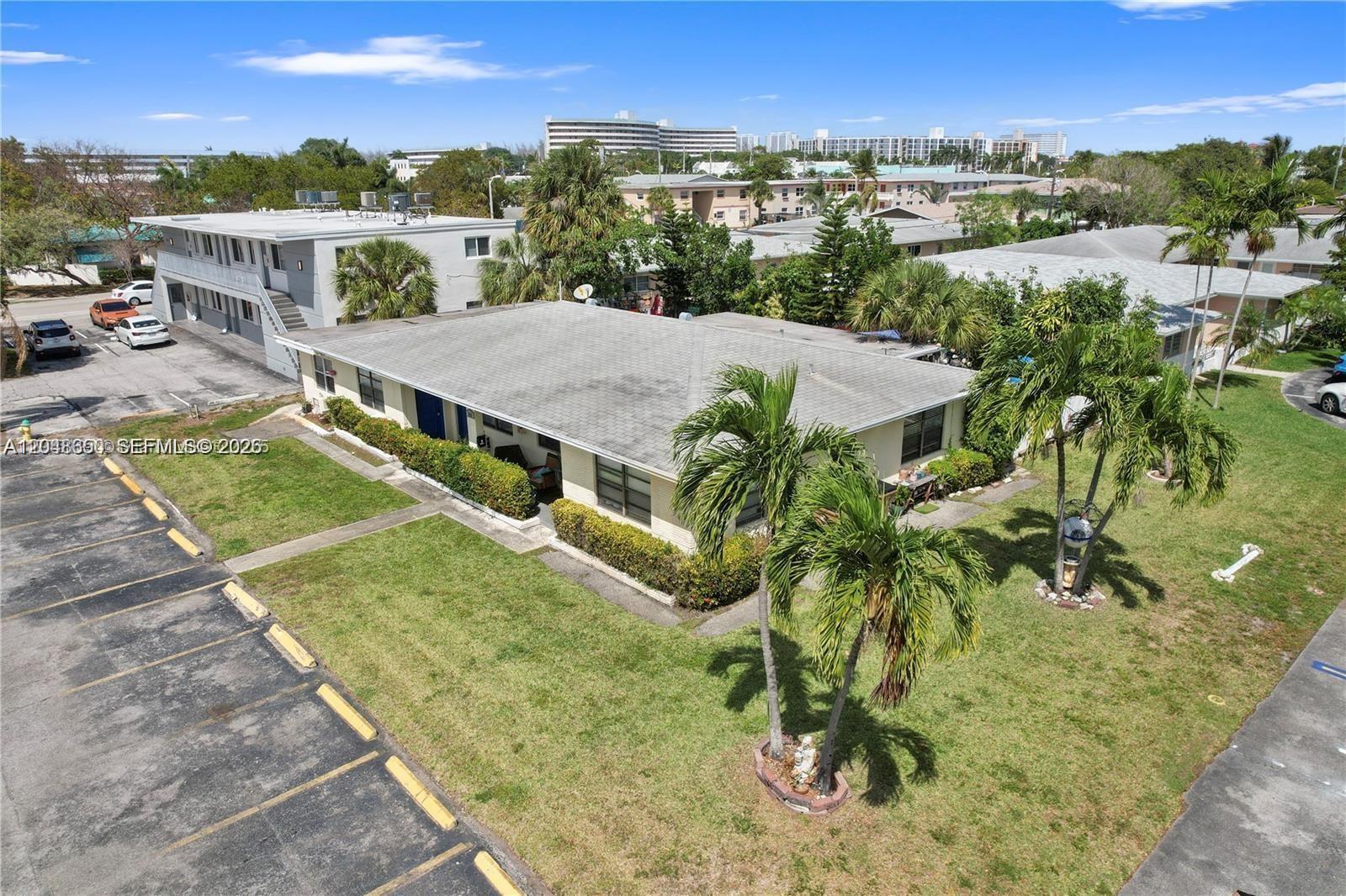 A single-story white brick house features a covered porch, dark-framed windows, and manicured hedges — 380 SE 12th Ave # 2, Deerfield Beach FL 33441, DEERFIELD BEACH, FL