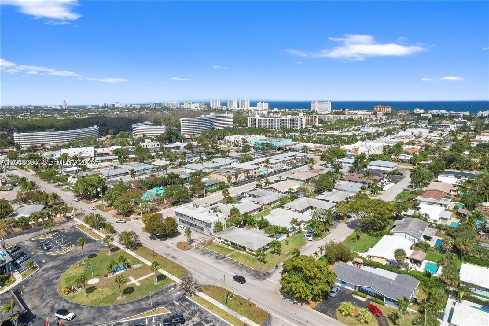 An aerial view shows a residential neighborhood with low-rise buildings, streets, and distant ocean views — 380 SE 12th Ave # 2, Deerfield Beach FL 33441, DEERFIELD BEACH, FL