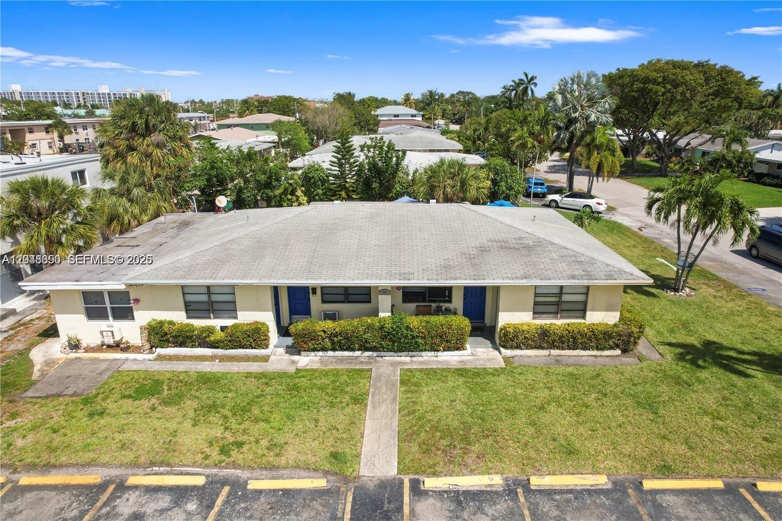An open-concept living area features wood-look flooring and a kitchen with white cabinetry — 380 SE 12th Ave # 2, Deerfield Beach FL 33441, DEERFIELD BEACH, FL