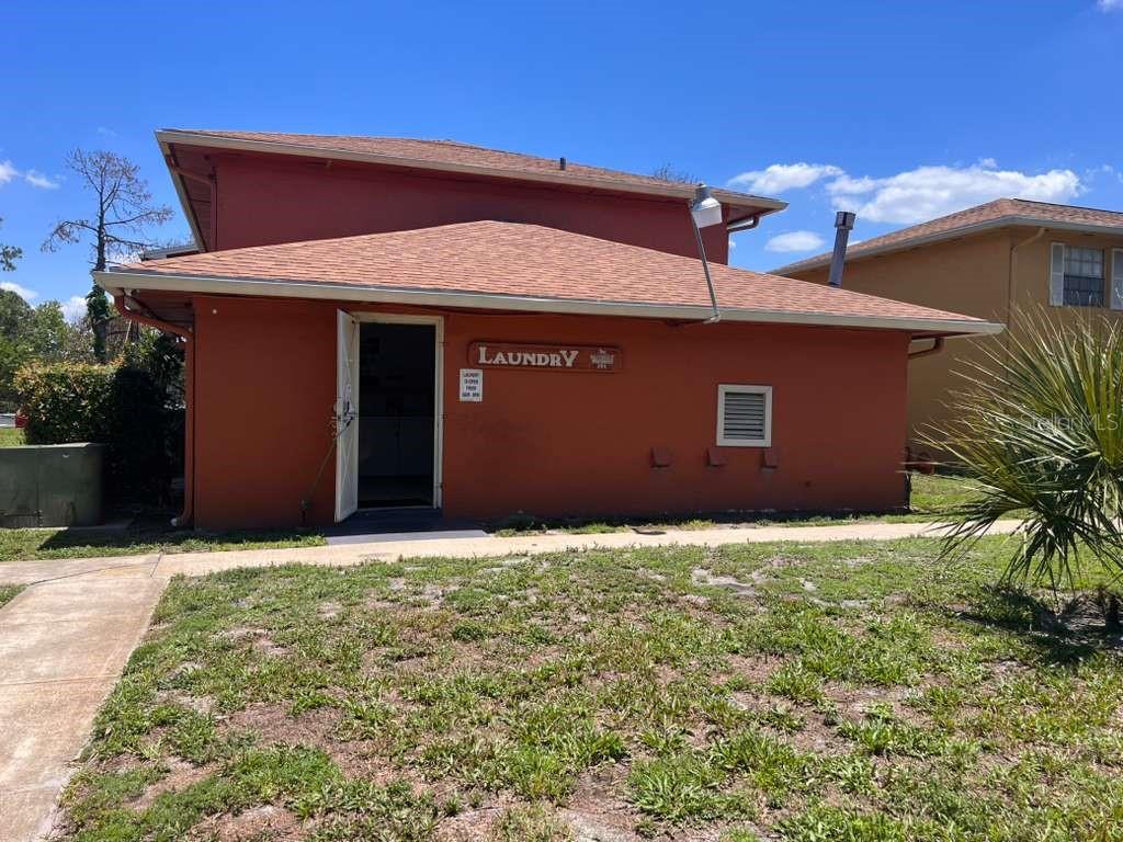 A red exterior building with a laundry sign above an open doorway — 1665 W OAK RIDGE ROAD UNIT C, ORLANDO, FL