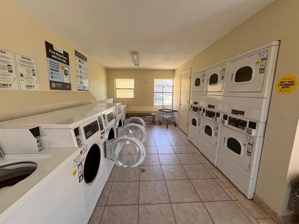A laundry room features multiple stacked washers and dryers, tiled floors, and two windows — 1665 W OAK RIDGE ROAD UNIT C, ORLANDO, FL